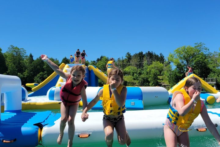 kids jumping in the water at sheboygan quarry beach's aqua park in sheboygan, wisconsin